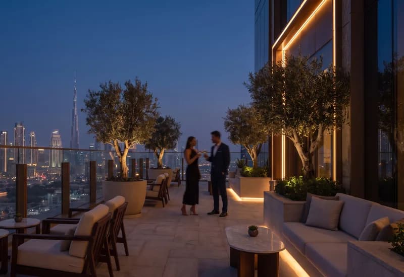 Guests talking on a rooftop restaurant terrace overlooking the Dubai skyline at dusk.